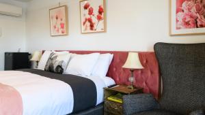 戴尔斯福特Daylesford Art Motel的配有一张床和一把椅子的酒店客房