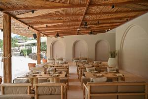 邦涛海滩Arinara Beach Resort Phuket - SHA Extra Plus的餐厅设有木制天花板和桌椅