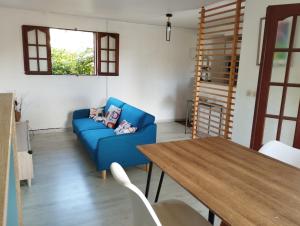 哥西尔Bas de Villa Dumont T3 avec jacuzzi的客厅配有蓝色的沙发和木桌
