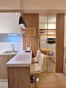 伊洛伊洛Iloilo Travellers Zen Zone的厨房配有水槽和带椅子的柜台。