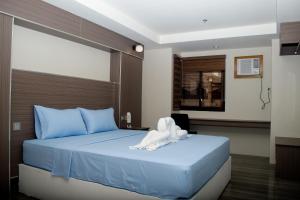 奥隆阿波RedDoorz @ Washington Guest House Olongapo的一间酒店客房,配有一张带毛巾的床
