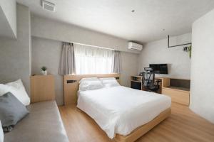 福冈脈 -MYAKU PRIVATE SAUNA-的卧室配有一张白色大床和电视。