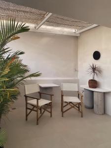 莲三AMBERGRIS的一间房间,配有两张桌子和两把椅子,还有一棵植物