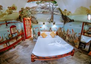 科隆椰子花园度假酒店的一间设有一张壁画床的房间
