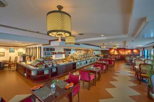 科泽科德拉维兹卡利卡特酒店的一间带桌椅的餐厅和一间酒吧