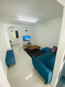 珍南海滩Simple2 Guesthouse的客厅配有蓝色的沙发和电视
