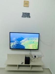 珍南海滩Simple2 Guesthouse的挂在白色墙壁上的平面电视