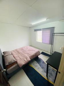 珍南海滩Simple2 Guesthouse的一间小卧室,配有一张床和一张桌子