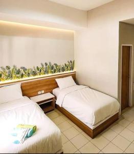 GondowulungCaniga Hotel Yogyakarta的酒店客房的两张床