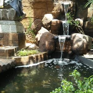 GondowulungCaniga Hotel Yogyakarta的花园中的喷泉