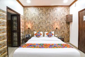 加尔各答FabExpress New Diamond的卧室配有一张带彩色枕头的大型白色床。