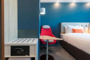 阿斯塔纳Holiday Inn Express - Astana - Turan, an IHG Hotel的配有床和红色椅子的房间