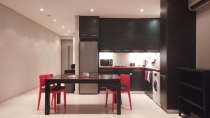 温特和克Business Pro Apartment, Windhoek的厨房配有黑桌和红色椅子