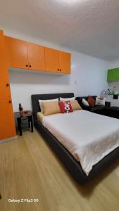 碧瑶MNK Condo Transient - Albergo Residences的一间卧室配有一张大床和一张沙发