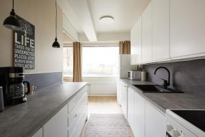 图尔库Jokiranta asunto, Free-park的厨房配有白色橱柜、水槽和窗户。