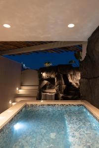 莫诺利索斯Aegean Diamonds Luxury Suites的一座带岩石墙的房屋内的游泳池