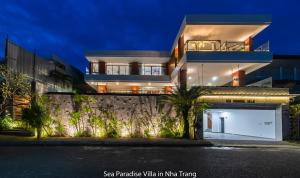 芽庄Promotion Early Booker, Sea Paradise Villa 6 Bedrooms, Infinity Pool, Karaoke, Sauna & BBQ的大楼前有车库的房子