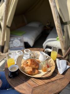 蓬托尔松Camping Haliotis的一张桌子,上面有一盘食物和饮料