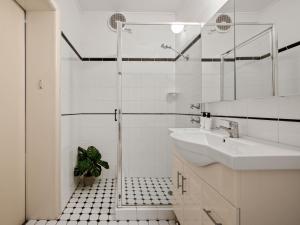 肯图巴肯图巴大都会宾馆的白色的浴室设有水槽和淋浴。