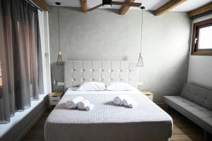 特尔斐Komody的一间卧室配有一张床,上面有两条毛巾