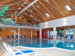 穆劳附近圣洛伦岑Spacious Chalet near Ski Area in Sankt Georgen ob Murau的一座带椅子的建筑内的游泳池