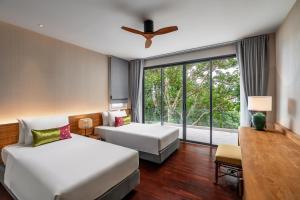 查龙Noku Phuket的酒店客房设有两张床和窗户。