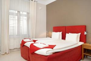 赫尔辛堡Stadsparken Apartments的卧室配有红色的床和白色枕头