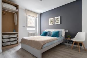 阿尔巴塞特Apartamento Manola con terraza junto al Corte Inglés的一间卧室配有一张带蓝色枕头的床