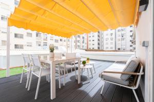 阿尔巴塞特Apartamento Manola con terraza junto al Corte Inglés的阳台配有桌椅和黄色雨伞。