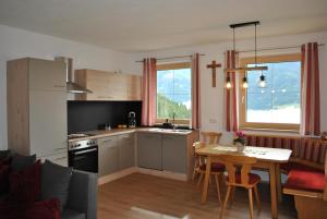 韦伯格Ferienwohnung Gipfelblick的厨房、带桌子的客厅和用餐室