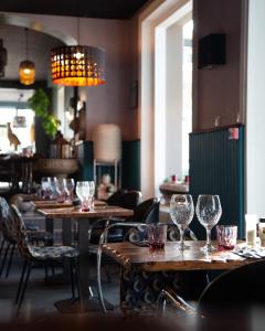 瑞卢维尔莱潘Hôtel des Pins的配有桌椅和酒杯的餐厅