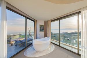 贝莱克Maxx Royal Belek Golf Resort的带浴缸的浴室和大窗户