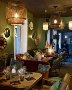 瑞卢维尔莱潘Hôtel des Pins的餐厅设有长桌、椅子和吊灯