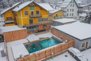 巴德加斯坦AlpinSpa zur Post的雪中带游泳池的房子