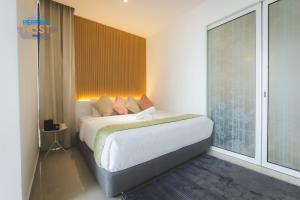 哥打京那巴鲁The Shore Kota Kinabalu By Perfect Host Borneo的一间卧室设有一张床和一个大窗户