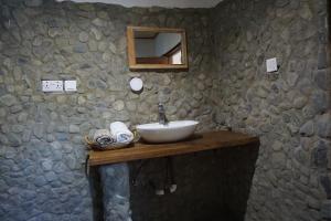 Obo可可村宾馆的一间带水槽和石墙的浴室