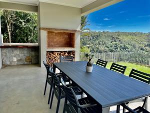 赫罗德斯湾Hilltop 39, Oubaai Golf Estate的带壁炉的庭院配有蓝色的桌椅
