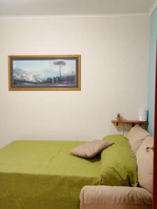 那不勒斯Dreaming Vesuvio Napoli的卧室配有一张绿色的床,墙上挂着一幅画