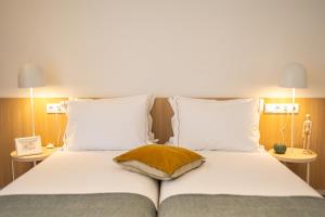 塞亚Watts House的一张带白色床单和棕色枕头的床