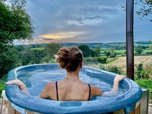 莱明斯特Romantic Escape with Hot Tub & Countryside Views的坐在大型充气泳池中的女人
