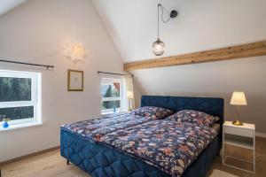 塞埃巴克Haus Wiesenruhe的一间卧室设有蓝色的床和窗户。