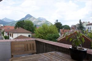 格勒诺布尔3 min sortie A480: wifi fibre - lit bébé - balcon的阳台设有长凳,享有山脉背景。