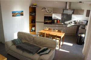 格勒诺布尔3 min sortie A480: wifi fibre - lit bébé - balcon的客厅配有沙发和餐桌,厨房配有桌子