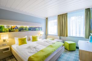 诺伊豪森Ferien Hotel Spree-Neisse的酒店客房配有一张带黄色枕头的大床