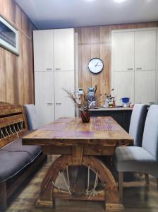 第聂伯罗Резидент的用餐室配有木桌和墙上的时钟