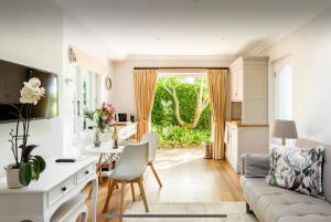 开普敦Guest suite - Leafy Constantia Guest House的厨房以及带沙发和桌子的客厅。
