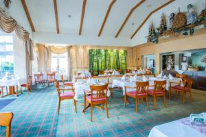 诺伊豪森Ferien Hotel Spree-Neisse的一间设有白色桌子和红色椅子的餐厅