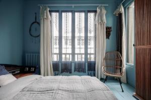 巴黎MAISON MOUZ的一间卧室设有一张床、一个窗口和一把椅子