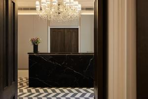 伦敦埃克尔斯顿广场酒店的走廊上设有镜子和吊灯