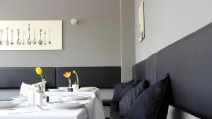 爱尔福特林登内克公寓式酒店的用餐室配有白色的桌子和蓝色的椅子